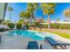 Beautiful backyard showcasing a sparkling pool with lounge chairs, lush landscaping, and mature palm trees at 6220 E Paradise Ln, Scottsdale, AZ 85254