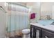 Well-lit bathroom featuring a vessel sink, modern fixtures, and a shower/tub combination with stylish curtain at 6245 W Maya Dr, Phoenix, AZ 85083