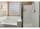 Close up of tub and shower area featuring glass block window to provide natural light at 6245 W Maya Dr, Phoenix, AZ 85083