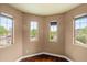 Corner bedroom featuring wood floors, tan walls, and multiple windows with neighborhood views at 6245 W Maya Dr, Phoenix, AZ 85083