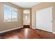 Bedroom with wood floors, closet, and view into hallway with neutral paint and tile floor at 6245 W Maya Dr, Phoenix, AZ 85083