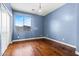 Bedroom features hardwood floors, a chandelier, blue walls, and a view of the community at 6245 W Maya Dr, Phoenix, AZ 85083