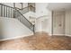 Spacious open-concept living room featuring tile flooring, tall ceilings and a staircase with dark wood trim at 6245 W Maya Dr, Phoenix, AZ 85083