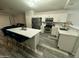 Bright, modern kitchen with stainless steel appliances, quartz counters, and breakfast bar seating at 6920 S 46Th Dr, Laveen, AZ 85339