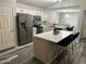 Kitchen with stainless steel appliances, an island with seating, and gray wood floors at 6920 S 46Th Dr, Laveen, AZ 85339