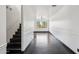 Hallway with dark wood floors, bright white walls and large window at the end of the hall at 7601 E Roosevelt St # 1007, Scottsdale, AZ 85257