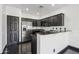 A modern kitchen featuring dark wood cabinetry and stainless-steel appliances and fixtures at 7601 E Roosevelt St # 1007, Scottsdale, AZ 85257
