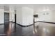 A living room features dark hardwood floors and a curved wall opening to the kitchen at 7601 E Roosevelt St # 1007, Scottsdale, AZ 85257