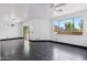 A living room with a ceiling fan, hardwood floors, and a large picture window at 7601 E Roosevelt St # 1007, Scottsdale, AZ 85257