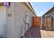Side view of a house with a gate to the backyard and utilities on the wall at 809 W Kingman Dr, Casa Grande, AZ 85122
