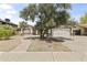 Charming single-story home with a walkway leading to the front door, and a mature tree providing shade at 8234 W Sweetwater Ave, Peoria, AZ 85381