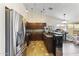 Well-equipped kitchen featuring stainless steel refrigerator, dark wood cabinets, tile backsplash, and modern lighting at 8234 W Sweetwater Ave, Peoria, AZ 85381