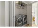 Functional laundry room featuring modern washer and dryer units, and storage shelves at 8234 W Sweetwater Ave, Peoria, AZ 85381