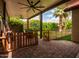 Inviting covered back patio with brick flooring, ceiling fans, lush landscaping and a -safe gate at 936 E Gila Ln, Chandler, AZ 85225
