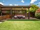 Seating area under covered patio with outdoor furniture and well manicured artificial grass lawn at 936 E Gila Ln, Chandler, AZ 85225