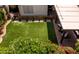 Backyard with well-maintained artificial grass lawn, patio area, and beautiful, mature landscaping at 936 E Gila Ln, Chandler, AZ 85225