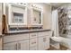 Bathroom featuring dual sinks, vanity, and shower with a tile wall, adding style and convenience at 936 E Gila Ln, Chandler, AZ 85225