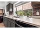 Modern kitchen sink with quartz countertop, gray cabinets, tile backsplash and a window overlooking the backyard at 936 E Gila Ln, Chandler, AZ 85225