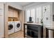 Bright laundry room with white washer/dryer units, ample storage and a black table and shutters for natural light at 936 E Gila Ln, Chandler, AZ 85225