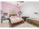 Cozy bedroom featuring plush pink bedding, fun decor, and an adjacent study area at 9548 E Grandview St, Mesa, AZ 85207