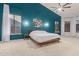 Large main bedroom with teal accent wall, carpet floors, stylish lighting and bedside table at 9548 E Grandview St, Mesa, AZ 85207