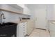 Functional laundry room featuring a sink, washer, dryer, and plenty of storage space at 9548 E Grandview St, Mesa, AZ 85207