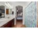 Bathroom with double sinks, and a shower/tub, leads into a bedroom with a ceiling fan at 11410 W Davis Ln, Avondale, AZ 85323