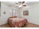 Bedroom with ceiling fan, window, and a bed with a vibrant quilt, offering comfort and functionality at 11410 W Davis Ln, Avondale, AZ 85323