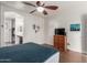Bedroom with a ceiling fan, wood dresser, and connecting bathroom with a sink at 11410 W Davis Ln, Avondale, AZ 85323