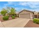 Single-story home featuring desert landscaping, a spacious driveway, and a neutral-toned exterior at 11410 W Davis Ln, Avondale, AZ 85323