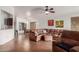 Open-concept living room with tile floors, a ceiling fan, and a comfortable leather sectional at 11410 W Davis Ln, Avondale, AZ 85323