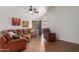 Cozy living room with tile floors, a ceiling fan, and a comfortable leather sectional at 11410 W Davis Ln, Avondale, AZ 85323