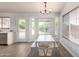 Bright dining area with a white table, modern chairs, a bay window, and wood-look flooring at 11520 W Lizard Ct, Surprise, AZ 85378