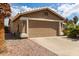 Attached two-car garage with neutral paint, a driveway, and desert landscaping at 11520 W Lizard Ct, Surprise, AZ 85378