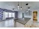 Kitchen island with marble countertop and views to the living room with a floral accent wall at 11596 W Sierra Dawn Blvd # 165, Surprise, AZ 85378