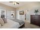Cozy bedroom featuring neutral tones, access to the en suite bathroom and views of the kitchen and living area at 11650 W Pincushion Ct, Surprise, AZ 85378