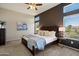 Comfortable main bedroom with elegant dark accent wall, and lots of natural light from multiple windows at 11650 W Pincushion Ct, Surprise, AZ 85378