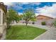 Lush backyard with green lawn, desert landscaping, and a cozy hammock at 1170 E Jardin Dr, Casa Grande, AZ 85122