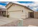 Side view of a tan single-Gathering house showcasing a two-car garage and desert landscaping at 1170 E Jardin Dr, Casa Grande, AZ 85122