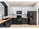 Modern kitchen with black and white cabinets, butcher block countertops, and stainless steel appliances at 1170 E Jardin Dr, Casa Grande, AZ 85122
