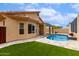 Well-maintained backyard features a pool, artificial grass, and a covered patio perfect for relaxation at 11808 E Clinton St, Scottsdale, AZ 85259