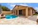 Backyard featuring a refreshing pool, covered patio, and travertine tile, ideal for outdoor entertaining at 11808 E Clinton St, Scottsdale, AZ 85259