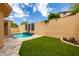 Inviting backyard oasis featuring a sparkling pool, lush artificial turf, and decorative wall accents at 11808 E Clinton St, Scottsdale, AZ 85259