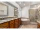 Elegant bathroom featuring double sinks with granite counters, tub, and glass shower at 11808 E Clinton St, Scottsdale, AZ 85259
