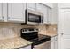 Kitchen featuring granite counters, tile backsplash, gray cabinets, and stainless steel appliances at 11808 E Clinton St, Scottsdale, AZ 85259