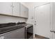 Laundry room with gray washer and dryer and overhead cabinets at 11808 E Clinton St, Scottsdale, AZ 85259