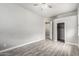 Bedroom with wood-look flooring, ceiling fan, closet, entry to en-suite bath and neutral paint at 1253 E Ivanhoe Ct, Gilbert, AZ 85295