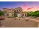 Charming two-story home featuring a desert landscape, tile roof, and beautiful sunset at 1253 E Ivanhoe Ct, Gilbert, AZ 85295