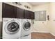 Convenient laundry room with washer, dryer, storage cabinets, and a window for natural light at 1253 E Ivanhoe Ct, Gilbert, AZ 85295
