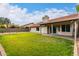 Charming backyard with green grass, partial covered patio, and privacy wall at 1333 E Bermuda Bay Ct, Gilbert, AZ 85234